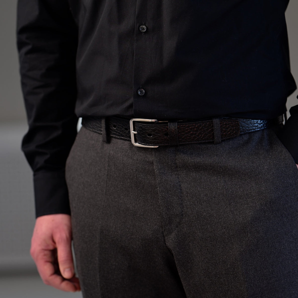 Mann mit grauer Wollhose und schwarzem Ledergürtel aus Bisonleder