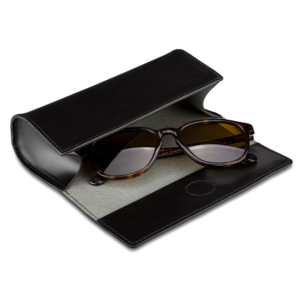 Brillenetui Cognac aus dickem, pflanzlich gegerbtem Leder in Schwarz, Verschluss mit eingearbeitetem Magneten. Fein sauber genäht. Hier geöffnet mit Sonnenbrille innen.